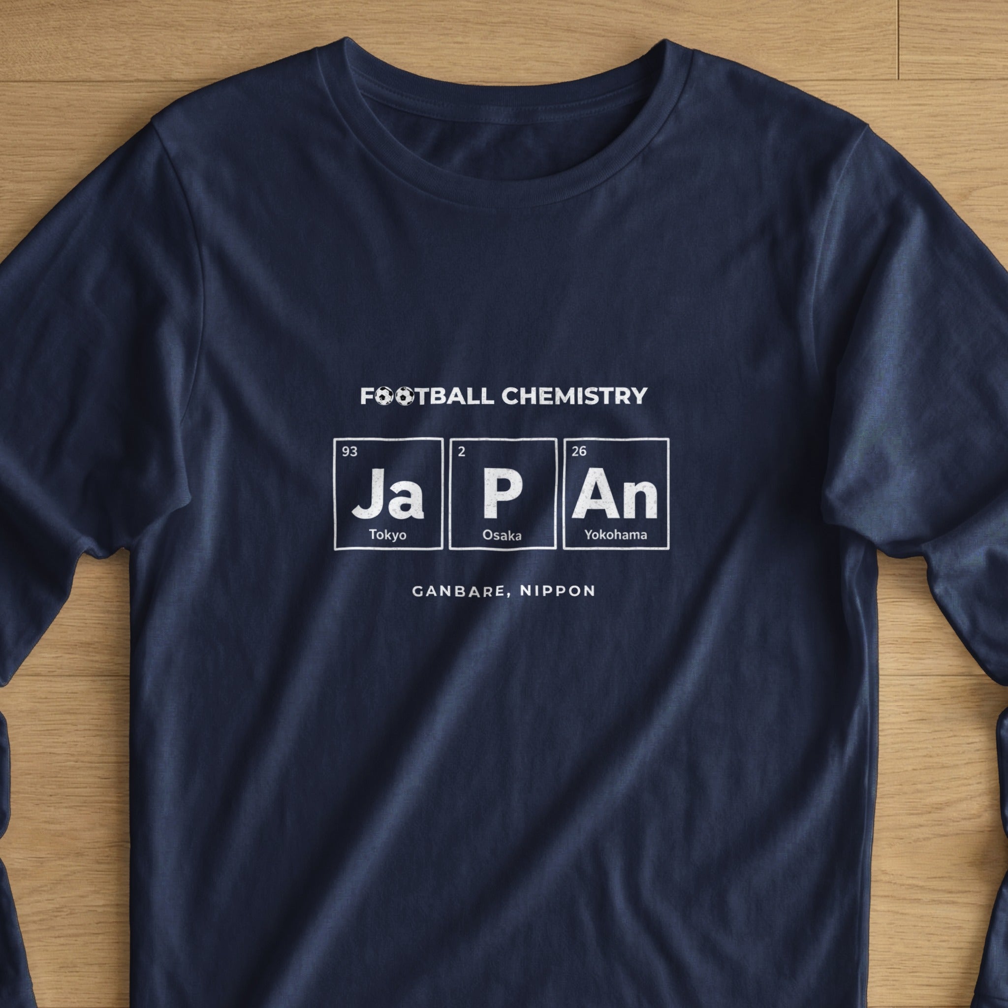 Navy t-shirt with "FOOTBALL CHEMISTRY" and periodic table elements "Ja", "P", "An" for Tokyo, Osaka, Yokohama.