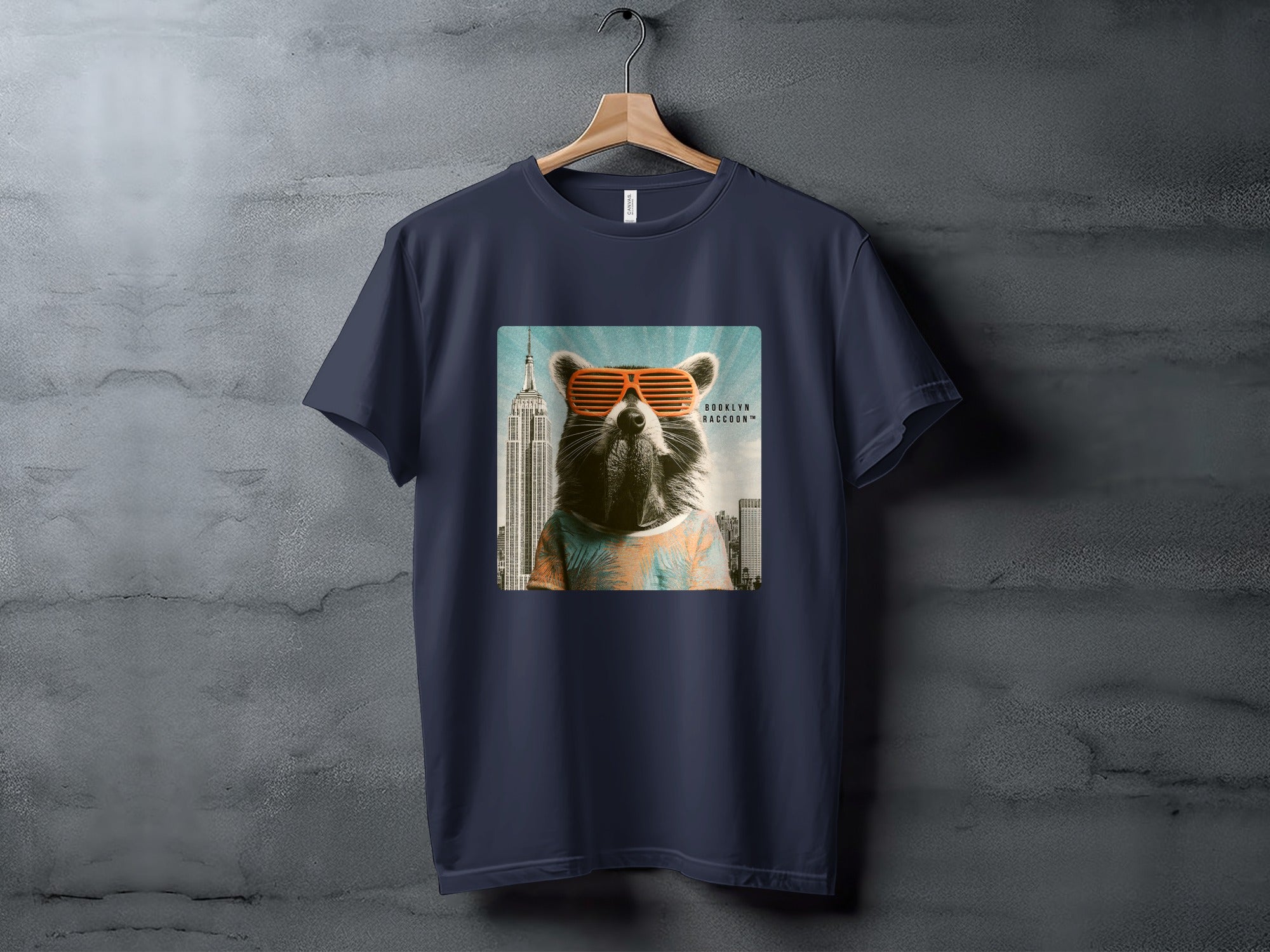 Raccoon wearing sunglasses in front of Empire State Building on navy t-shirt.