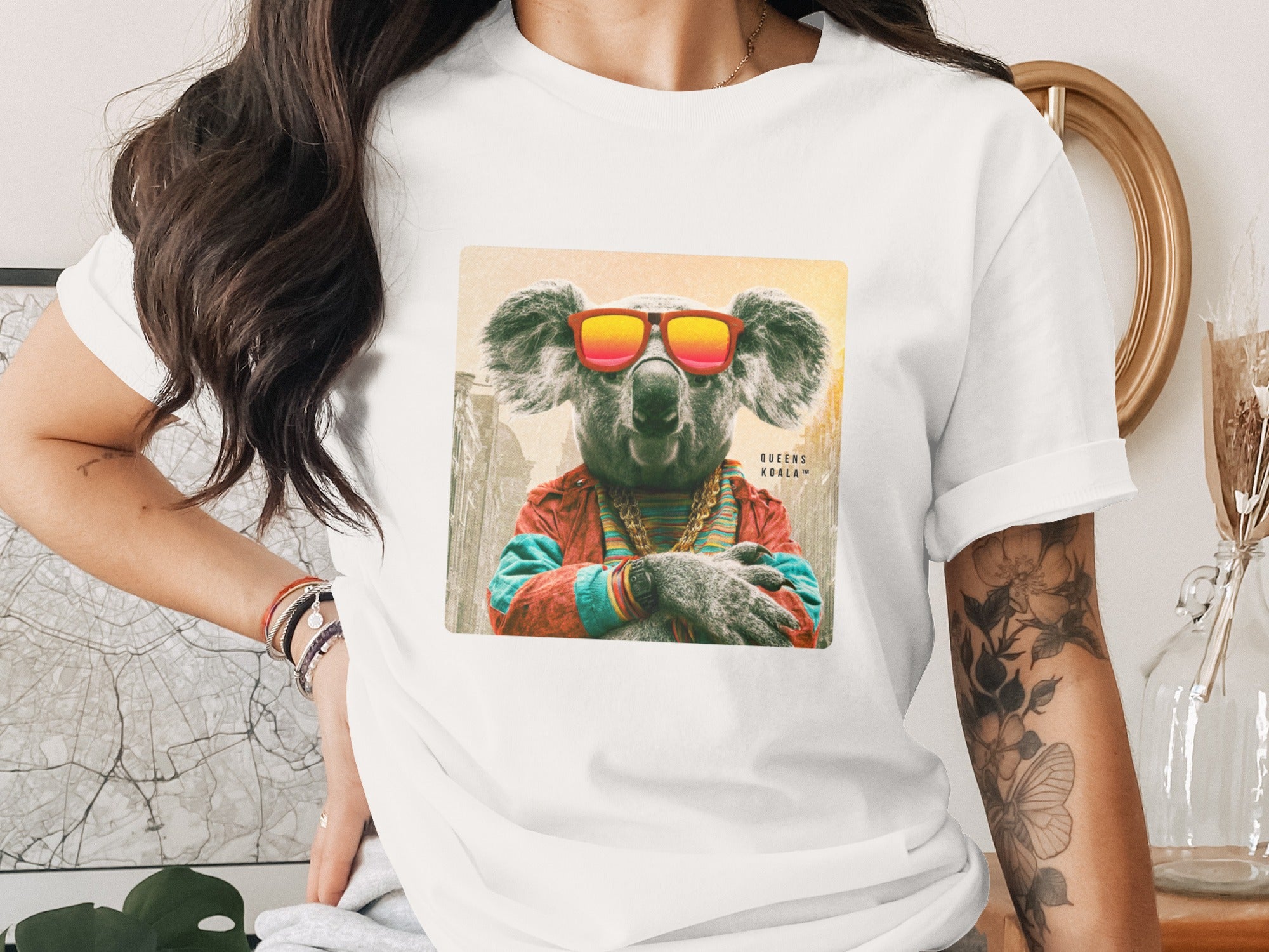 Koala in sunglasses and colorful jacket, arms crossed.