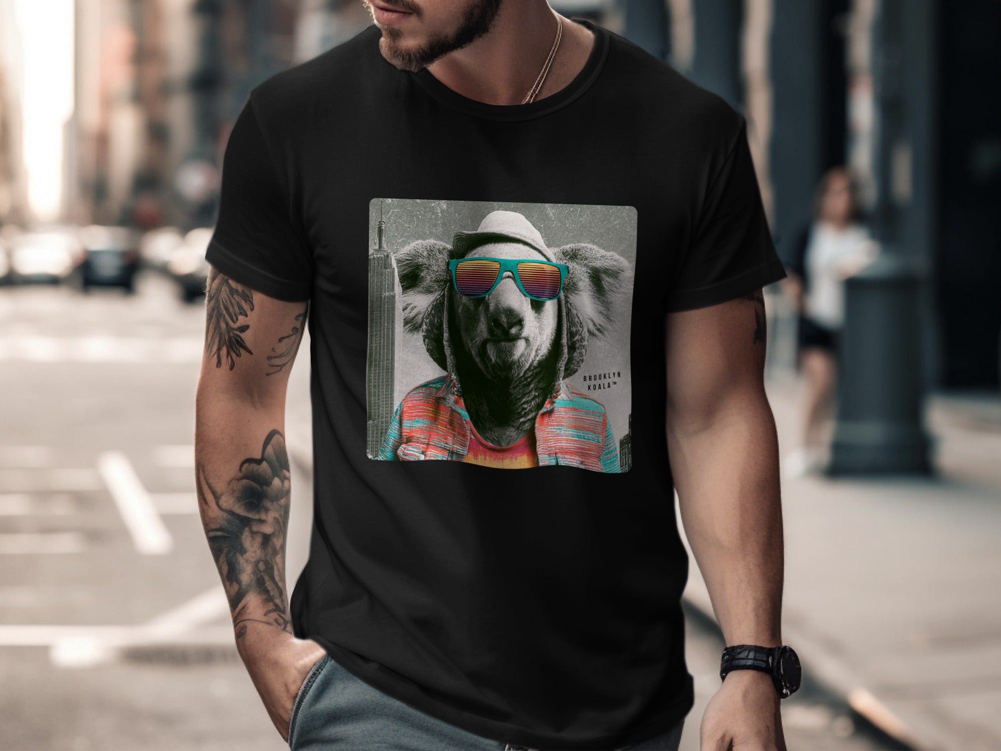 Koala wearing sunglasses and a colorful striped shirt on a black t-shirt.