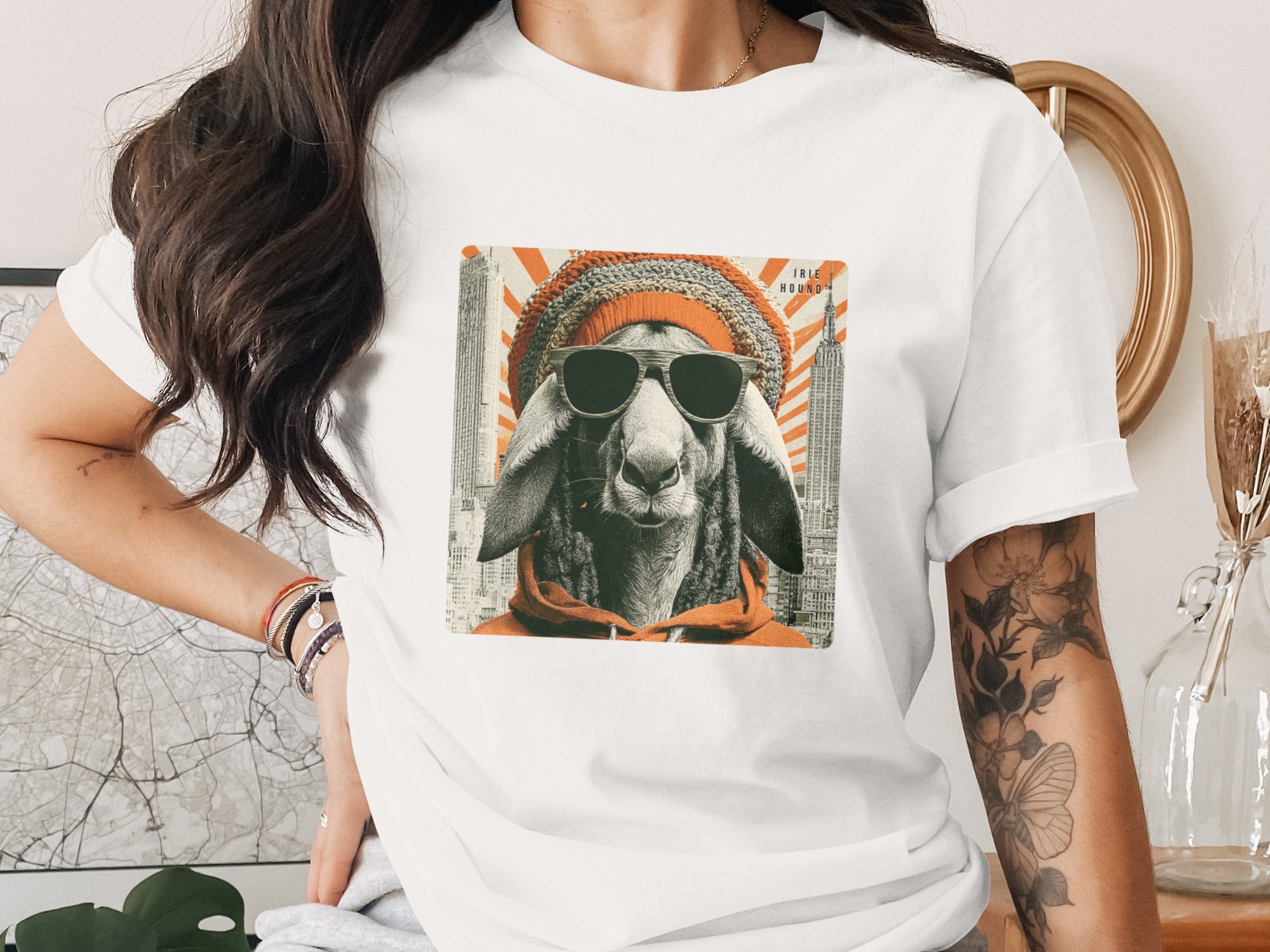 Sheep wearing sunglasses and a beanie, on a t-shirt with a city skyline.