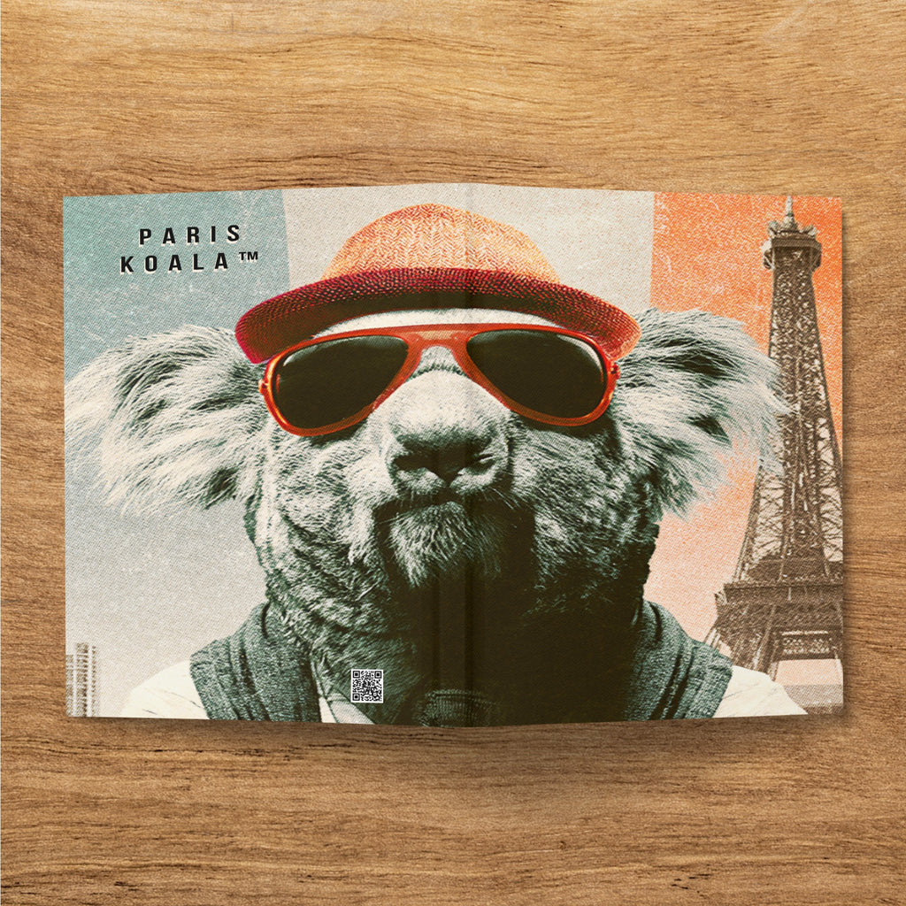 Koala wearing sunglasses and hat, with Eiffel Tower in background.