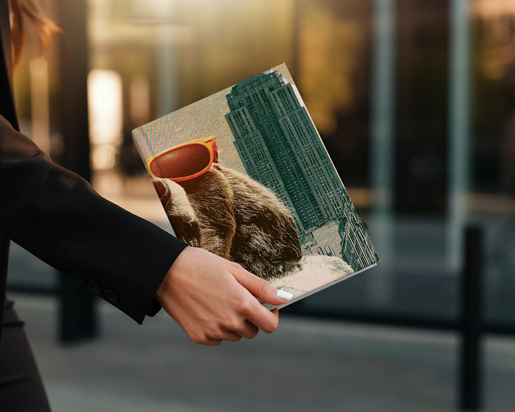 Notebook with sloth wearing sunglasses against city backdrop.