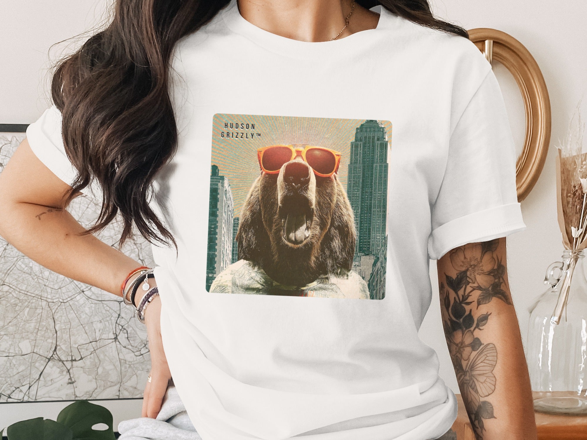 Grizzly bear wearing sunglasses with "Hudson Grizzly" text and city background.