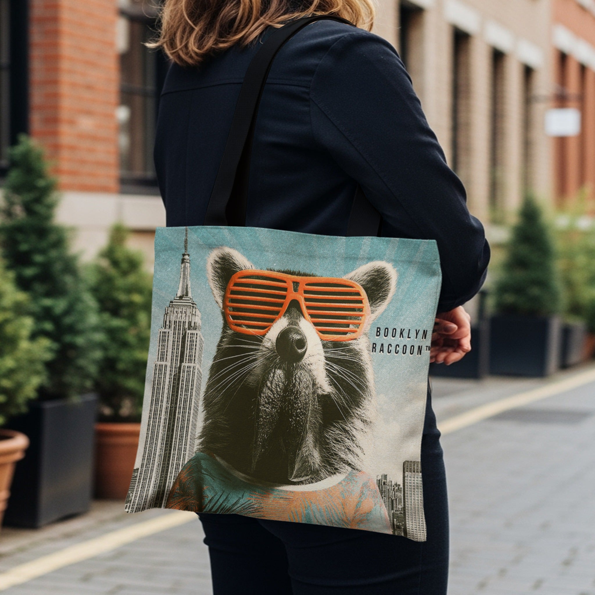 Tote bag with a raccoon wearing sunglasses in front of the Empire State Building.