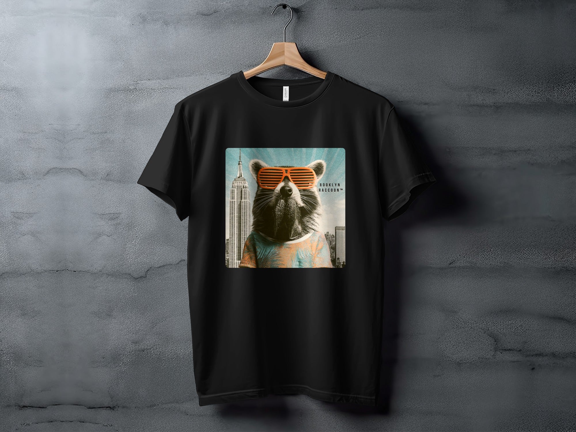Black t-shirt with a graphic of a raccoon wearing sunglasses in front of the Empire State Building.