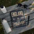 Notebook with England football team information and crest.