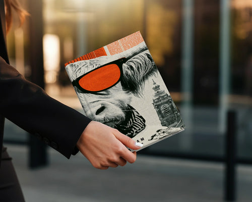 Woman holding magazine featuring a cow's face with orange sunglasses.