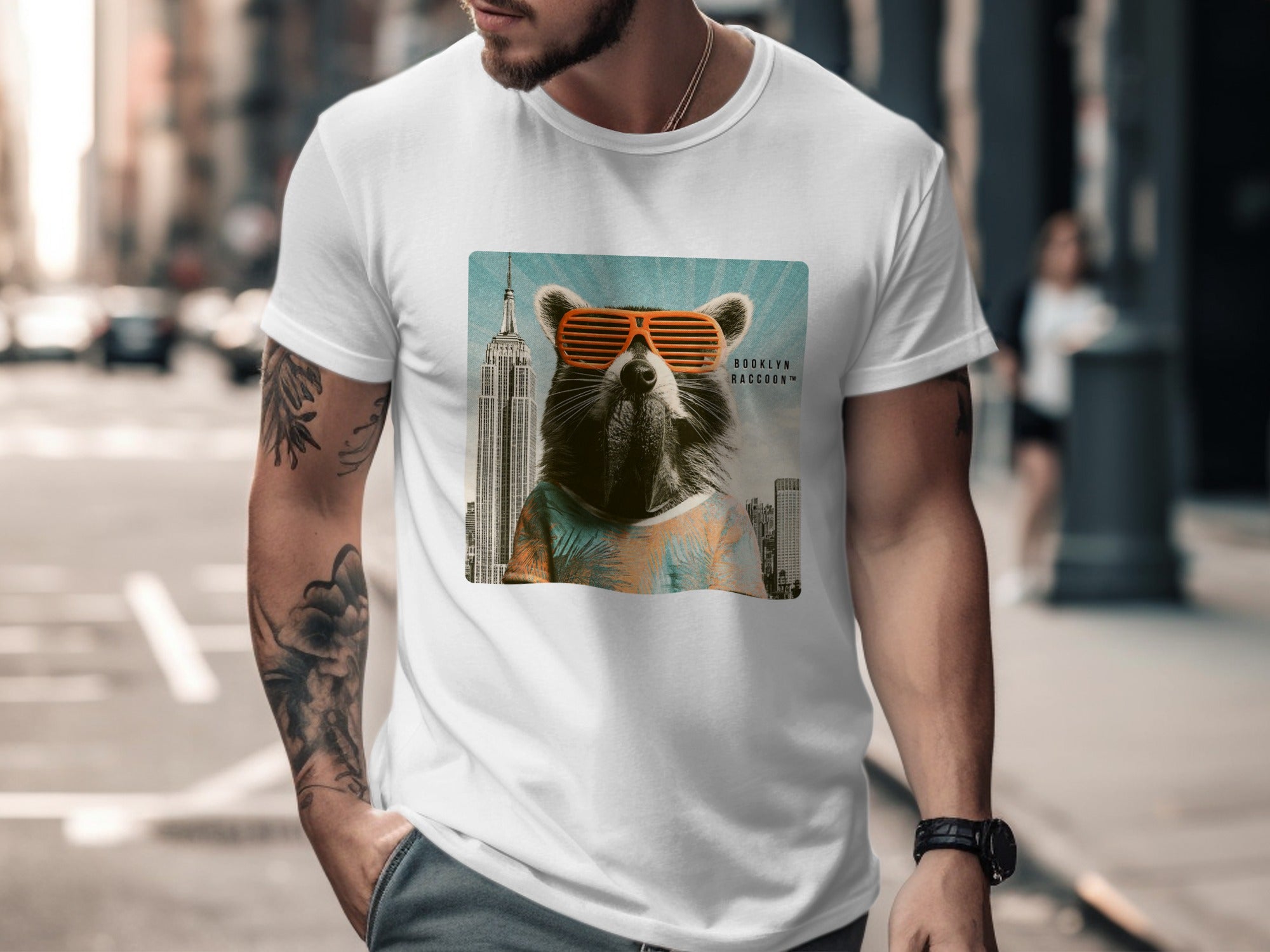 Man wearing t-shirt with raccoon graphic wearing sunglasses and city background.