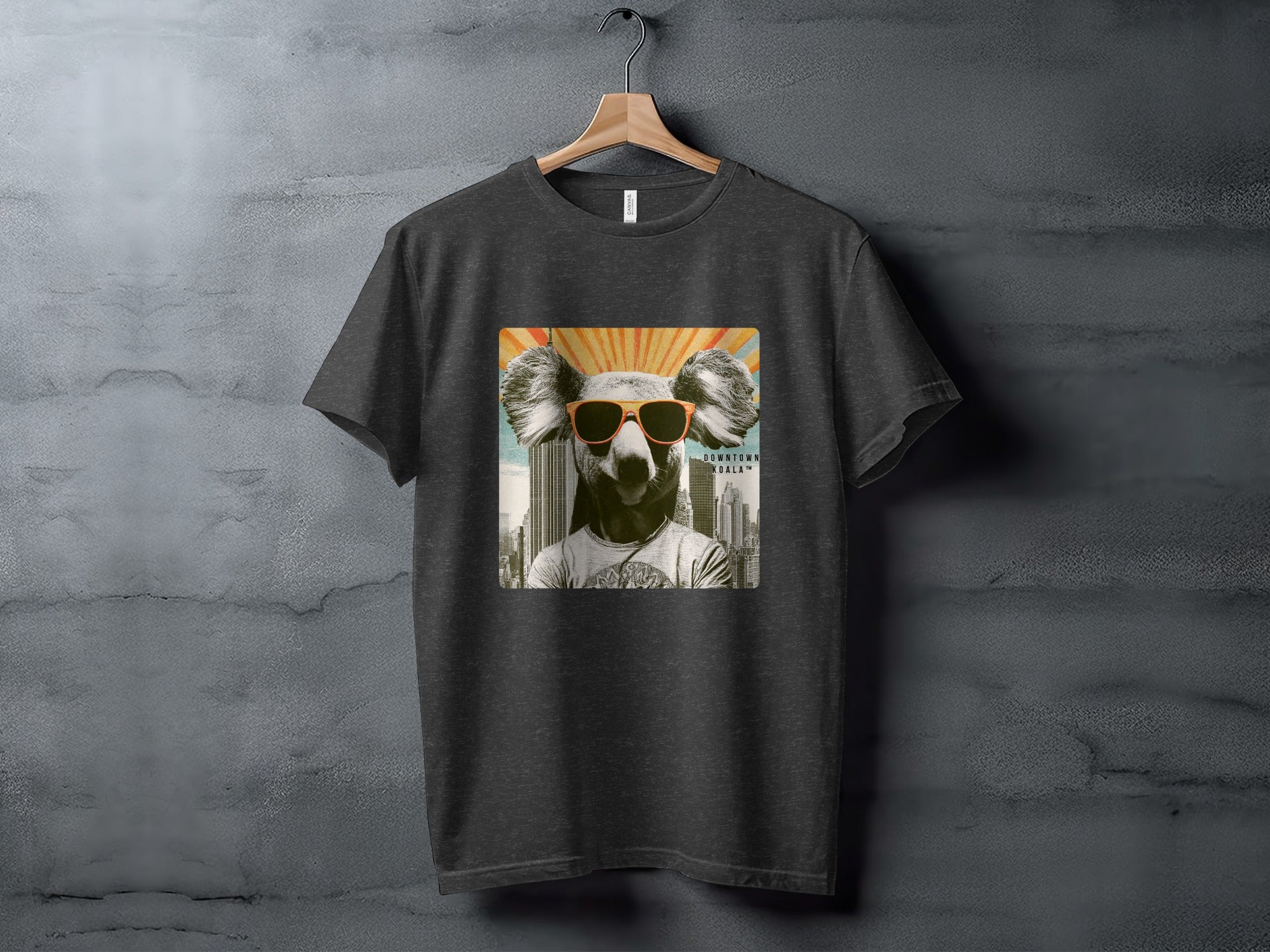 Dark t-shirt featuring a koala wearing sunglasses with a cityscape behind it.