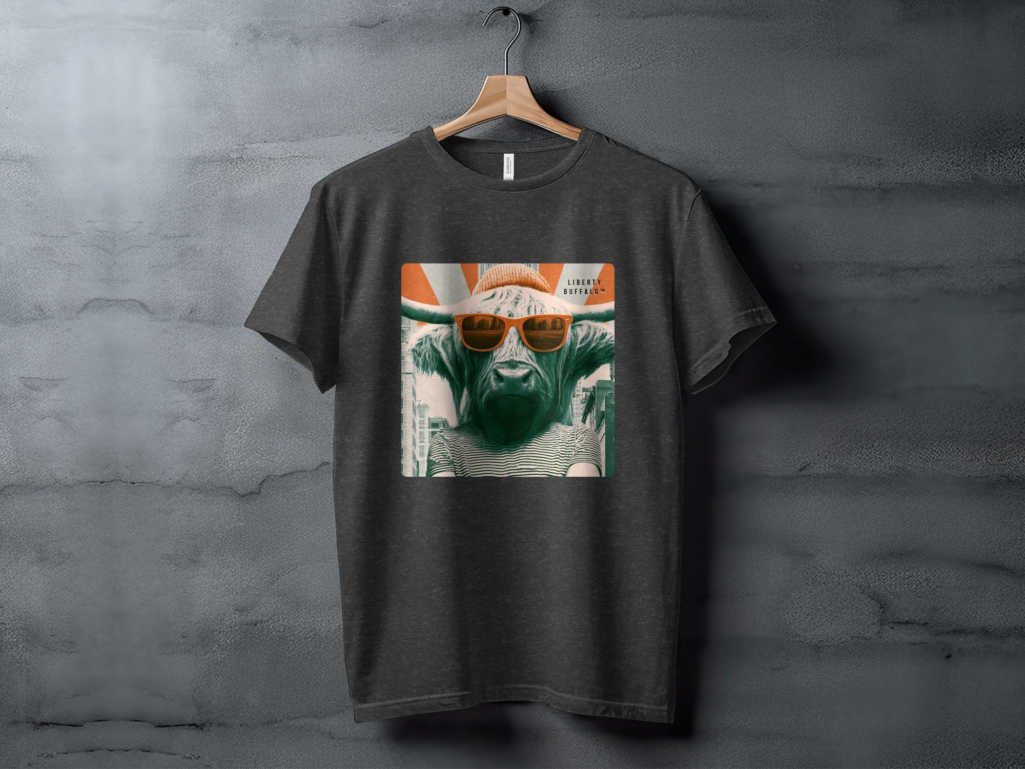 Dark t-shirt with graphic of cow wearing sunglasses and beanie.