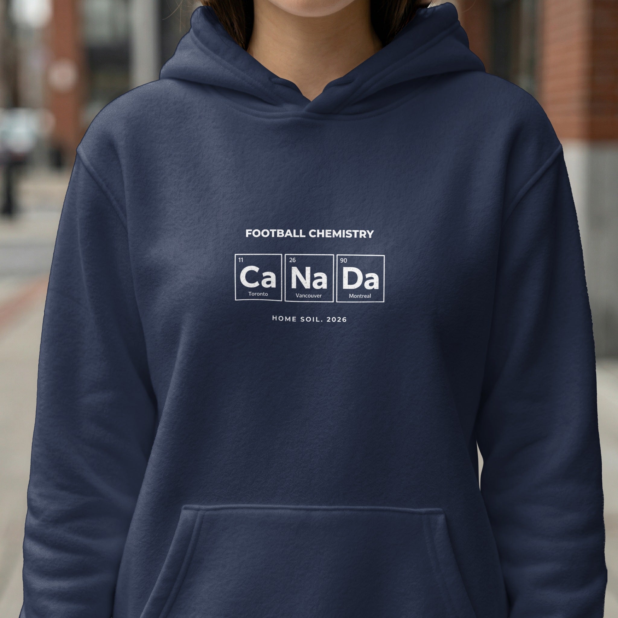 Navy hoodie with "Football Chemistry CaNaDa" design and "HOME SOIL. 2026".