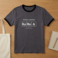 Dark grey ringer tee with "FOOTBALL CHEMISTRY" and periodic table elements for Korea.