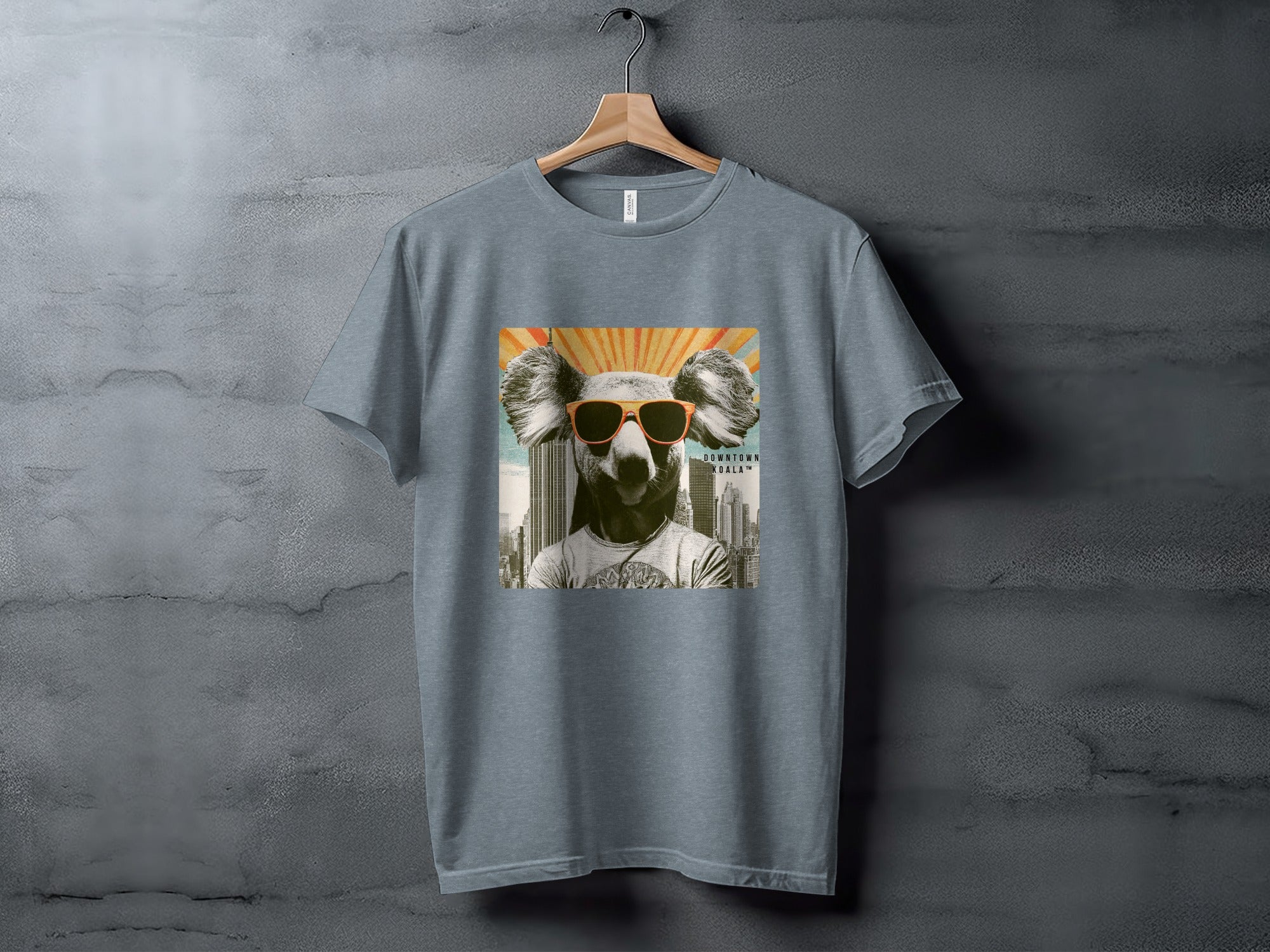 Grey t-shirt with a stylized koala wearing sunglasses against a sunburst background.