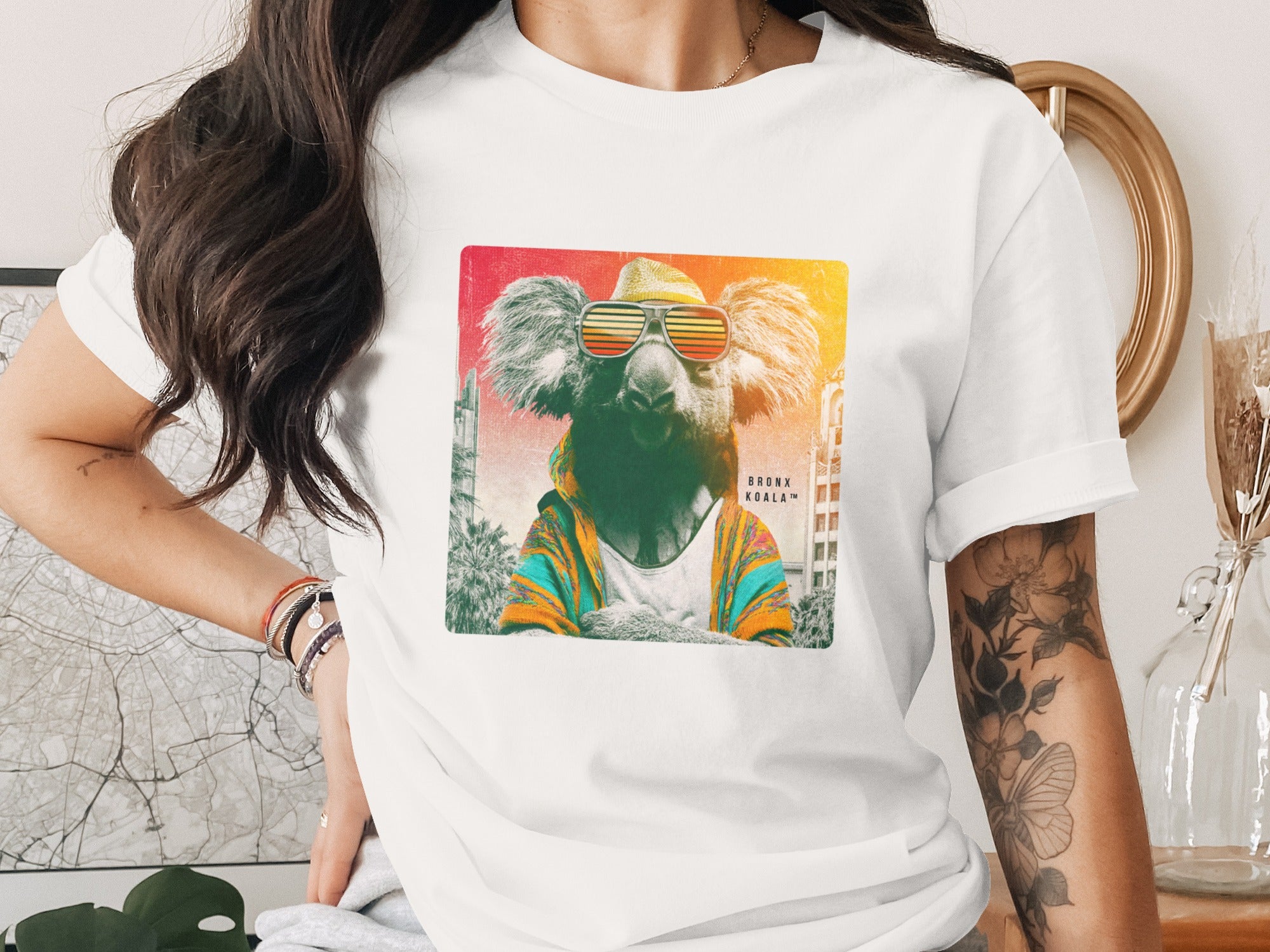 T-shirt with graphic of a koala wearing sunglasses and a colorful jacket.