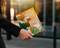 Woman holds a colorful book cover with a stylized portrait and "Bronx Koala" text.