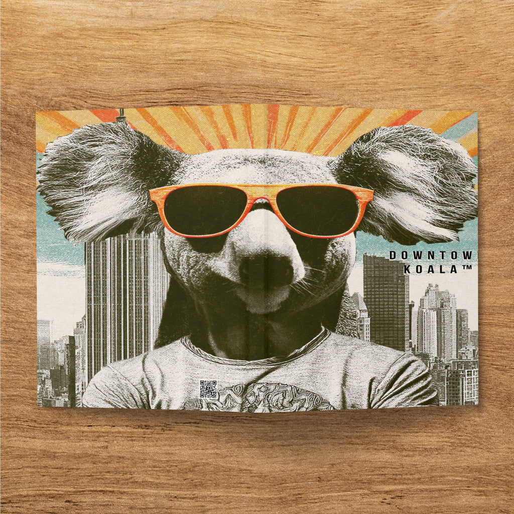 Koala wearing sunglasses and a t-shirt, with cityscape and sunburst background.