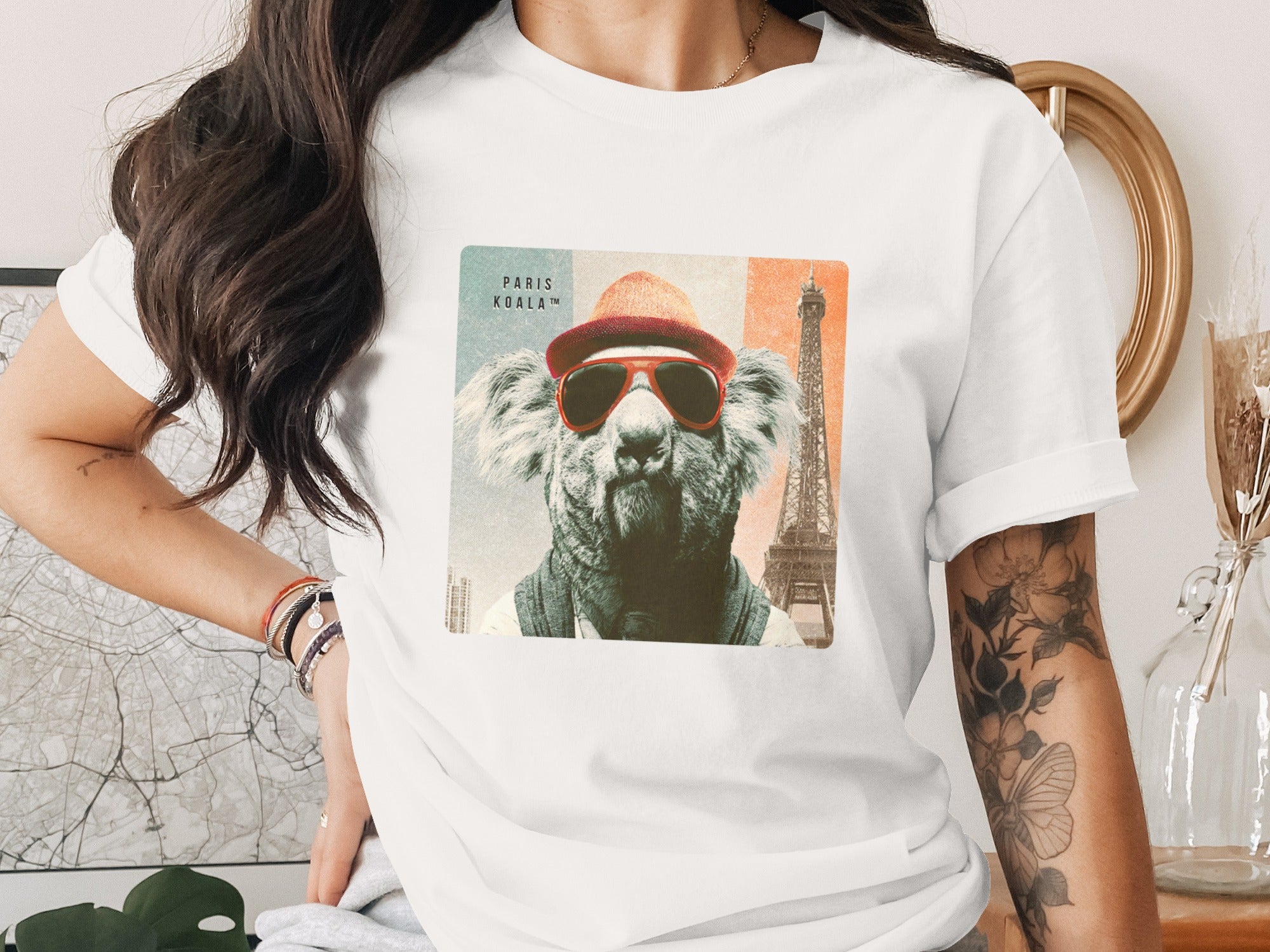 Koala wearing sunglasses and hat with Eiffel Tower on t-shirt.